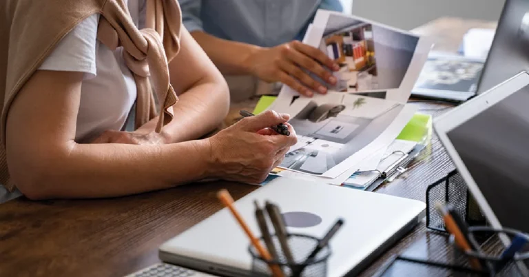 Graphic design collaboration between two professionals reviewing interior layout concepts at a modern workspace